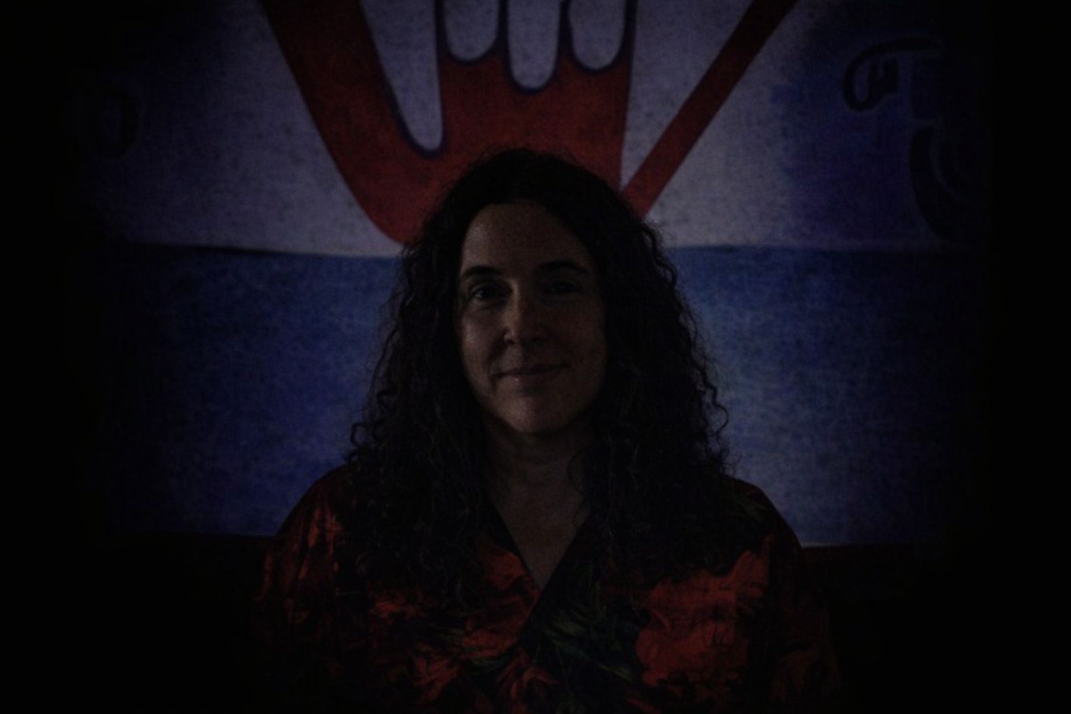 Porträtt av en kvinna framför en grafisk bakgrund i ett sociala medier-sammanhang.